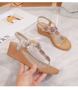 Dettaglio di strass a forma di girasole e suola a zeppa flessibile su sandali da donna