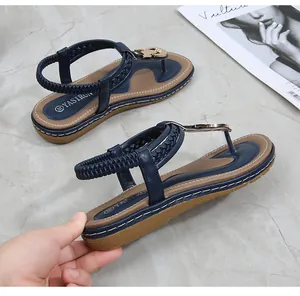 Detail view of navy blue thong sandals with gold buckle and woven textured straps