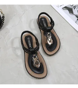 Detailed top view of black T-strap flip flops with golden buckle and elastic heel strap