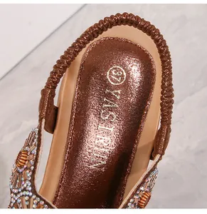 Dettaglio del sandalo bohémien con zeppa con fiori di strass e suola marrone imbottita