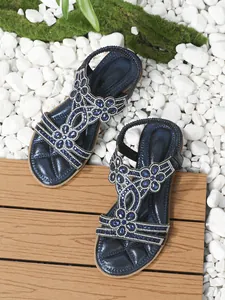 Detail of navy blue flat sandals with sparkling floral rhinestones and elastic heel strap