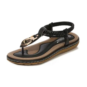 Women's black T-strap flip-flop sandals with gold buckle and brown flat soles