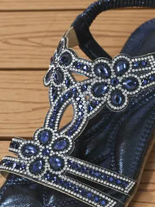 Close-up of blue rhinestone patterns and elastic heel strap on flat bohemian sandals
