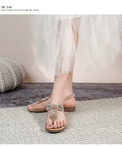 Detailaufnahme von böhmischen flachen Sandalen mit glitzernden Strasssteinen und Blumen