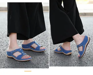 Detailansicht der Denim-Strasssandalen mit Kreuzriemen und Schnalle auf Keilabsatz