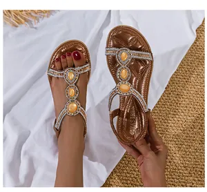 Detail von Boho-Sandalen mit großen gelben Edelsteinen und funkelnden Strasssteinen