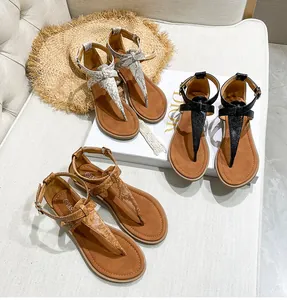 Overhead view of bohemian flat thong sandals in silver snake print, black, and brown