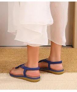 Gros plan de sandales tressées élastiques bleues avec semelle plate et couture blanche