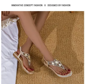 Dettaglio di sandali bassi bohémien color champagne con strass e cinturino a T