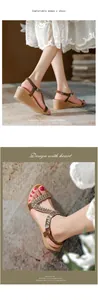 Dettaglio macro di sandali con zeppa marroni con motivi floreali di strass e cinturini incrociati