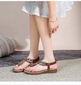 Detail von Boho-Flachsandalen mit funkelnden Strasssteinen und Blumenperlen