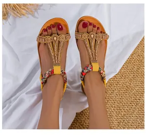 Detailansicht gelber Ethno-Sandalen mit bunten Perlen und gewebtem Fesselriemen