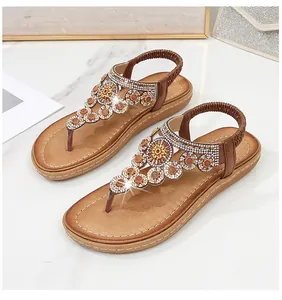 Nahaufnahme von Bohemian T-Strap-Sandalen mit Strasssteinen und Sonnenblumen-Perlen