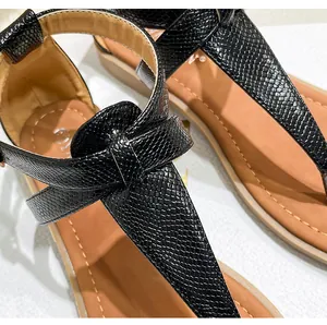 Detailed top view of black snake texture toe post sandals with brown stitched footbed