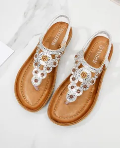 Nahaufnahme von Bohemian-Sandalen mit funkelnden Strasssteinen und Blumenakzenten