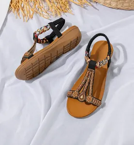 Detail von flachen Bohemian-Sandalen mit Perlen, Pailletten und elastischen Fersenbändern
