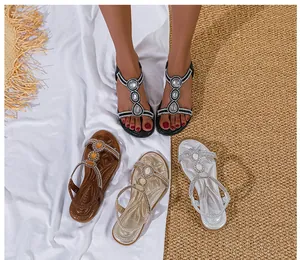 Detail von flachen Bohemian-Sandalen mit großen Kristallornamenten und Strasssteinen