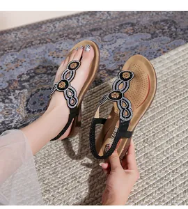 Detailaufnahme der böhmischen Keilsandalen mit floralen Strasssteinen und Fersenband