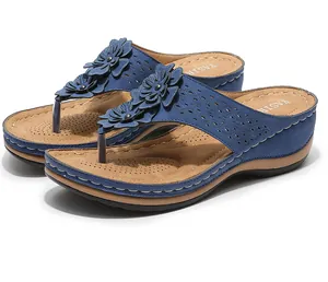 Détail de sandales compensées bleu marine avec fleurs 3D et motifs découpés au laser