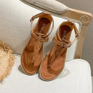 Close-up of brown snake skin textured T-strap sandals with adjustable ankle buckle