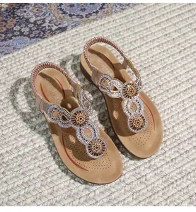 Details von böhmischen Keilsandalen mit funkelnden Strasssteinen und Blumen-T-Riemen