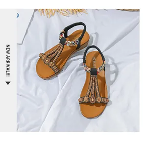 Detailaufnahme der ethnischen Keilsandaletten mit bunten Perlen und Boho-Mustern
