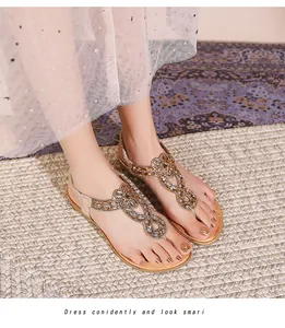 Détail de sandales bohèmes avec strass, bride élastique au talon et boucle en métal brillant
