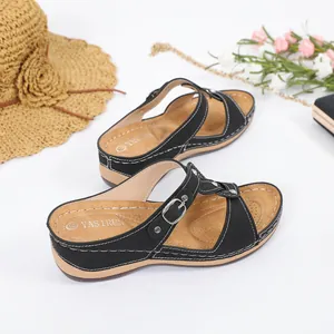 Nahaufnahme schwarzer Sommersandalen mit weißen Kontrastnähten und Metallschnallen