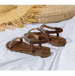 Detail von Boho-Sandalen mit funkelnden Strasssteinen und gelben Perlenriemen