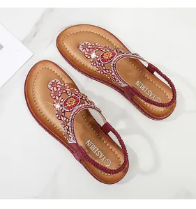 Details von roten Boho-Sandalen mit aufwendigen Strass-Blumen und Perlenstickerei