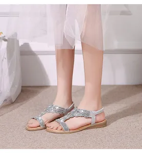 Close-up of bohemian silver flat sandals with sparkling rhinestones and elastic heel strap