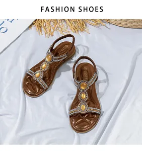 Detail von böhmischen braunen flachen Sandalen mit glitzernden Strasssteinen und Edelsteinen