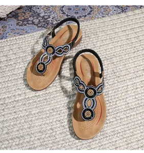 Detail von böhmischen Zehentrenner Sandalen mit Strassperlen und Goldblumenmustern