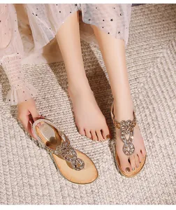 Détail de sandales bohèmes à lanière en T avec strass et motifs de vagues perlées
