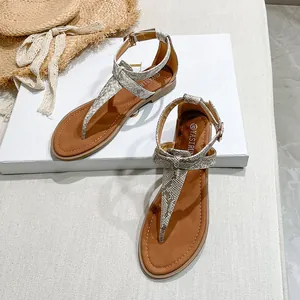 Detail of snakeskin print thong sandals with metallic ankle strap on summer props