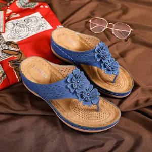 Détail de sandales compensées bleues avec fleurs 3D et semelle à texture tressée