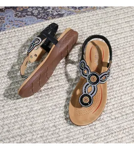 Detail von böhmischen Keilsandalen mit Strassperlen und ethnischen Pailletten-Verzierungen