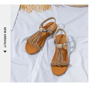 Detailansicht der Boho-Keilsandalen mit T-Riemen, Metallperlen und gewebten Blumen