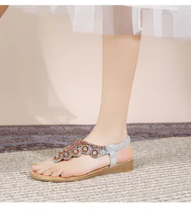 Λεπτομέρεια από ασημένια boho σανδάλια με περίτεχνη διακόσμηση από πορτοκαλί και λευκές χάντρες