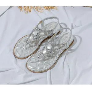 Dettaglio di sandali infradito argento con strass scintillanti e perle decorative
