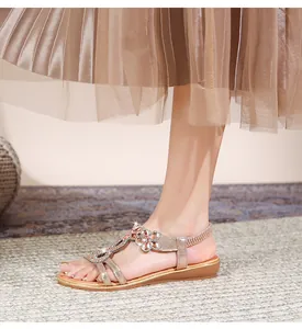 Detailansicht der Bohème-Sandalen in Champagnergold mit funkelnden Strassblumen