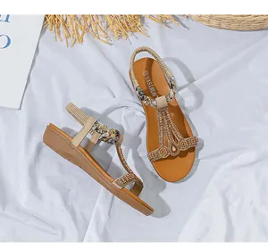Draufsicht auf böhmische flache Sandalen mit Perlen und Pailletten auf weißem Stoffhintergrund