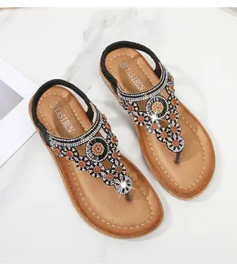Detail von Boho-Sandalen mit aufwendigen Blumenperlen und funkelnden Strasssteinen