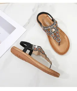 Detail der flachen Bohemian-Sandale mit Strassverzierungen und T-Riemen-Design