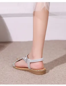 Close-up of silver flat sandals with sparkling rhinestones and elastic heel strap
