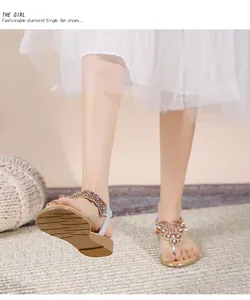 Λεπτομέρεια από boho φλατ σανδάλια με πολύχρωμα στρας σε μοντέλο στην παραλία