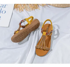 Detaillierte Draufsicht auf gelbe Keilsandalen mit T-Riemen und bunter Perlenverzierung