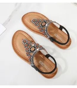 Detaillierte Draufsicht auf böhmische flache Sandalen mit Glitzersteinen und Perlenstickerei