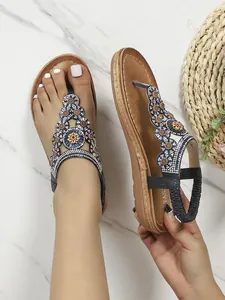Detail von böhmischen T-Riemen-Sandalen mit blauen Perlen und glitzernden Strasssteinen