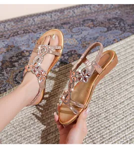 Details von roségoldenen flachen Bohème-Sandalen mit Strass-T-Riemen und Fersenband